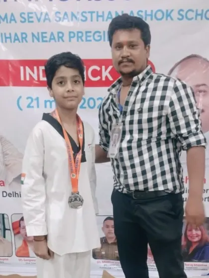 A young student proudly displaying his medal from the Delhi Olympic Games. Every competition is a valuable learning experience.