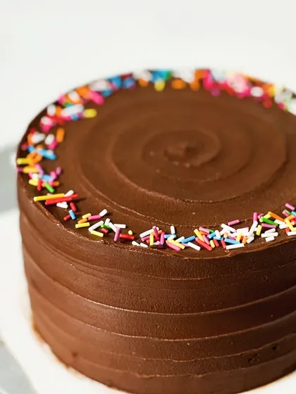 A full view of my Symphony Chocolate Cake. The simple swirl of ganache and a border of rainbow sprinkles make it a festive treat for any celebration.