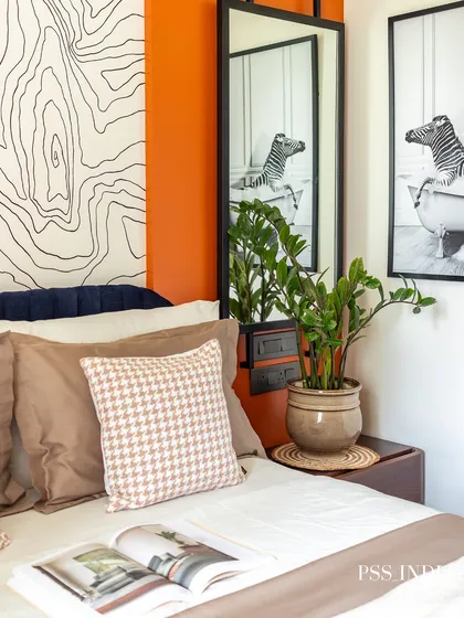 A close-up of the bedside styling, featuring a fun black and white photo of a zebra in a bathtub. A potted plant adds a touch of green, and the houndstooth pillow brings a classic pattern into the mix.