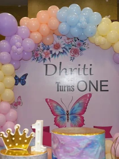 A close-up of the backdrop from a butterfly-themed first birthday. The pastel colors and floral details are very pretty.