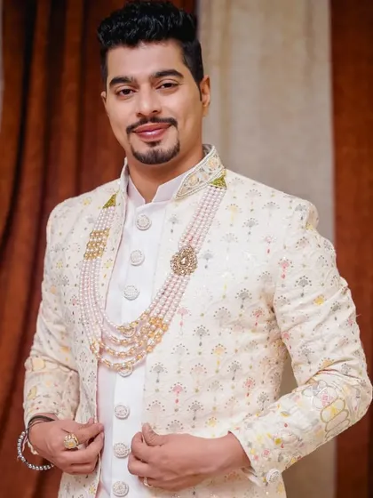 A portrait of the groom looking sharp and confident. The makeup is subtle, focusing on a clean and fresh look that complements his traditional wedding attire.