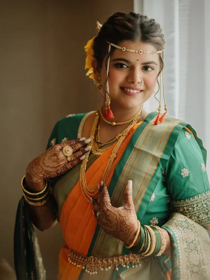 Enhancing natural elegance with a touch of artistry. This beautiful Maharashtrian bride glows in her traditional orange and green saree, with makeup that feels fresh and timeless.