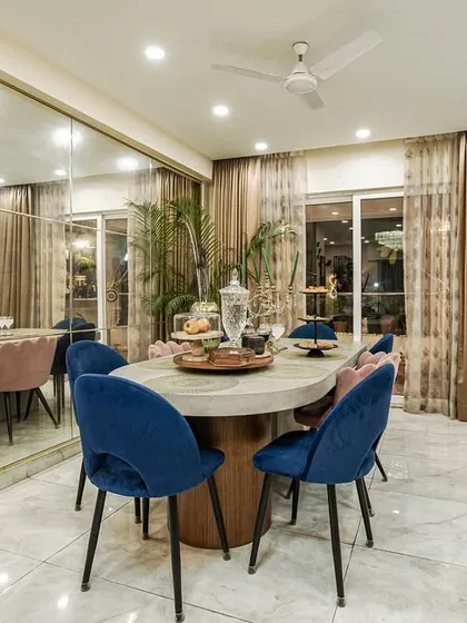 A different angle of the dining space from image 180, focusing on the elegant marble-top table and the interplay of pink and blue velvet chairs.