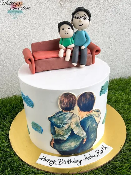A heartfelt cake for a father and son who share a birthday. The design features an edible print and a handmade fondant topper of the duo sitting together.