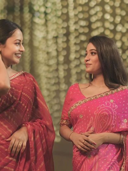 A shared glance under the festive lights of Dev Diwali. This candid portrait captures a moment of friendship and joy against a backdrop of glowing diyas.