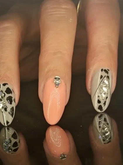A close-up of the animal print and rhinestone accent nails, showing the detailed gem work.