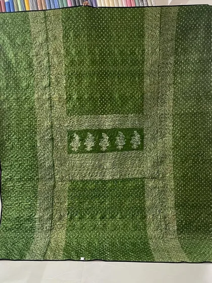 A reversible memory quilt made from two different sarees, one green and one orange, offering two distinct looks. This is the green side.