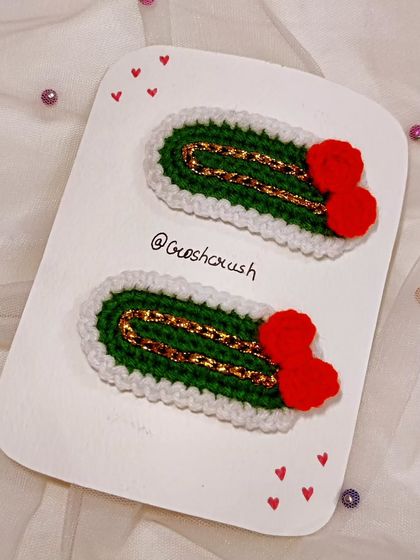 Vintage-style Christmas hairclips with a green base, gold thread detail, and a tiny red bow.