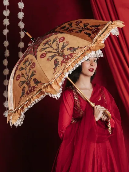 This image showcases another designer umbrella from the same collection, demonstrating the variety within the product line. The model's pose and gaze create a sense of elegance and storytelling, turning a product shot into a captivating portrait.