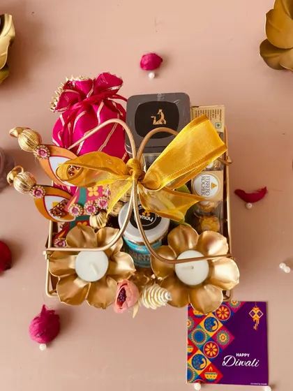 A top-down view of the luxe metal basket, showcasing the golden flower T-light holders and other festive goodies.