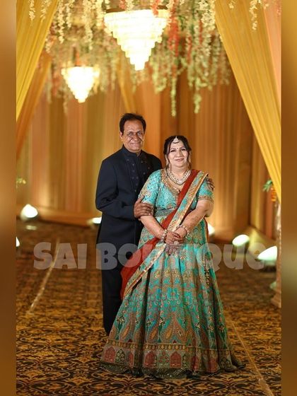 A lovely couple at a wedding. My client is wearing a beautiful turquoise lehenga with intricate embroidery, a perfect example of my custom bridal wear.