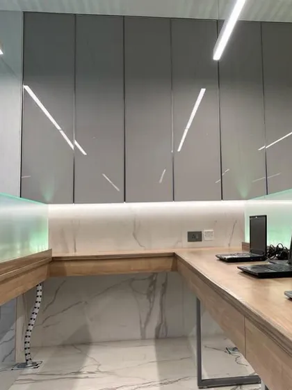 A detail of the workspace in the advocate's office, showcasing the clean lines of the high-gloss cabinetry, marble backsplash, and integrated lighting. The design is both highly functional and aesthetically pleasing.