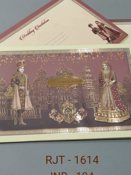 A classic invitation featuring a bride and groom in traditional royal attire against a palace backdrop. The gold foil detailing adds a touch of opulence to this timeless design.