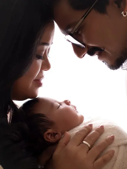 A beautiful silhouette shot of Bharti Singh and Haarsh Limbachiyaa with their newborn son, their foreheads touching.
