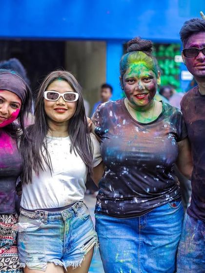 Friends covered in a rainbow of colors, enjoying the music and the festive atmosphere.