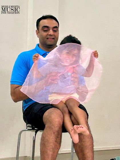 A game of peek-a-boo with a colorful scarf brings laughter and joy to our parent-toddler class, all while subtly teaching concepts like phrasing and dynamics.