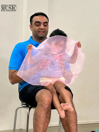 A game of peek-a-boo with a colorful scarf brings laughter and joy to our parent-toddler class, all while subtly teaching concepts like phrasing and dynamics.