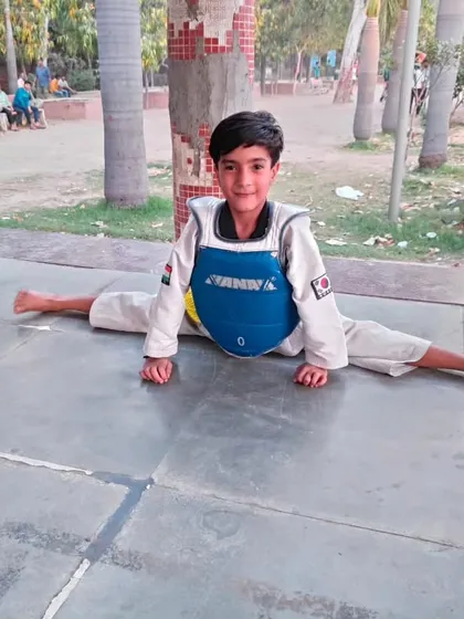 Flexibility is non-negotiable in martial arts. This young student demonstrates a perfect center split, a result of our dedicated flexibility training program which is essential for high kicks and injury prevention.