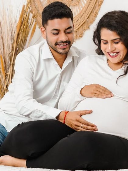 This candid moment shows the happy couple sharing a smile as they both hold the baby bump. It’s a natural, joyful interaction that reflects the shared excitement of their journey into parenthood.