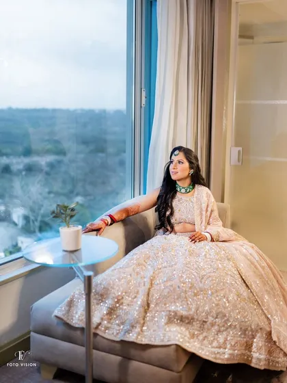 A pensive bridal portrait, with the bride looking out a large window, creating a beautiful, thoughtful moment before her wedding.