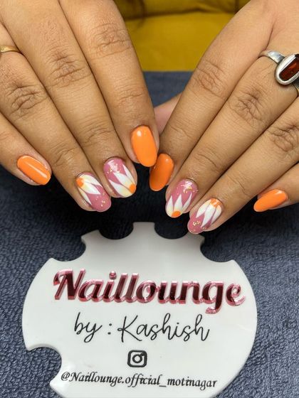 A perfect summer nail set with bright orange and hand-painted white and pink daisies.