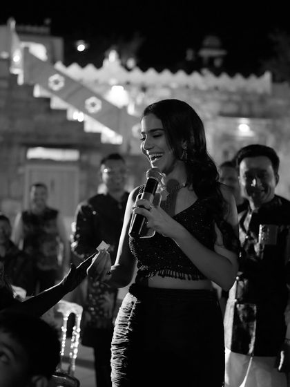A black and white shot capturing a moment of interaction during a sangeet. Even in stillness, you can feel the energy and connection with the audience.