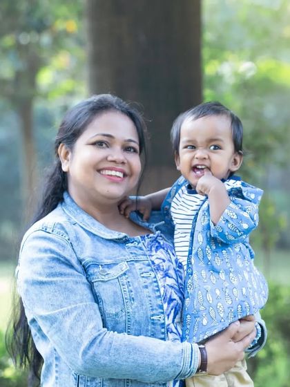 A mother holds her son, and they both share a joyful, open-mouthed smile. The coordinating denim outfits and the pure happiness on their faces make this a favorite.