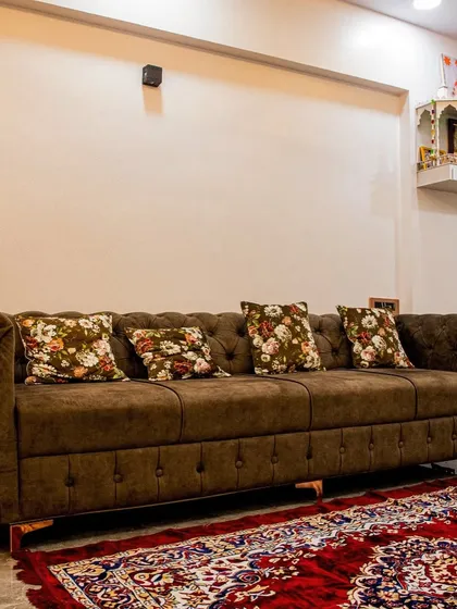 A classic tufted brown sofa paired with floral cushions, creating a cozy and timeless living room setting.