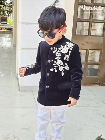 Ready for his close-up. This little client is all swag in our black velvet embroidered jacket, complete with sunglasses, proving that style has no age limit.