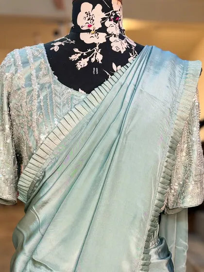 The blouse of the 'MANOHARI' saree features delicate pleating and embroidery, details that make each piece special.