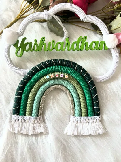A full view of the green-themed 'Yashwardhan' name hanging, laid out to show the complete cloud and rainbow design.