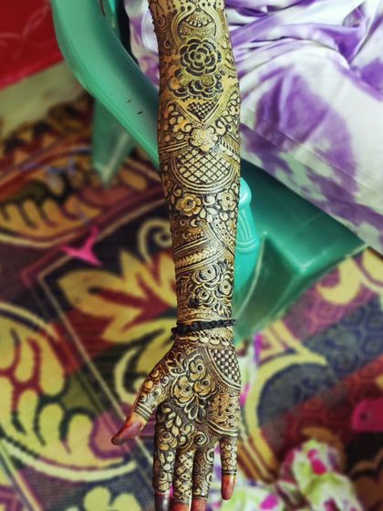 A single arm adorned with a dense and detailed bridal mehndi design, perfect for a bride who wants a traditional look.