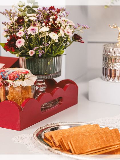 A festive tablescape featuring our Diwali collection, including a red scalloped tray, caramel cigar fingers, and a decorative reindeer jar.