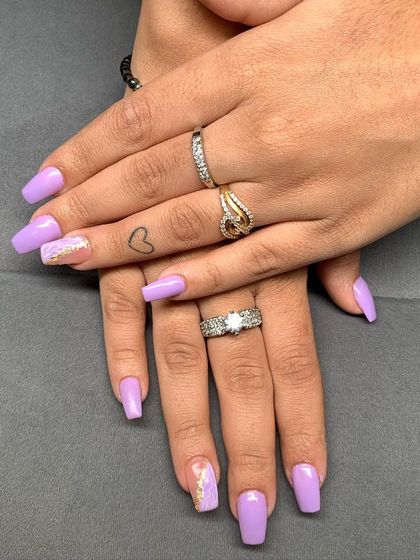 A full look at these beautiful lilac nails with gold foil accents, showing how they look on the hands.