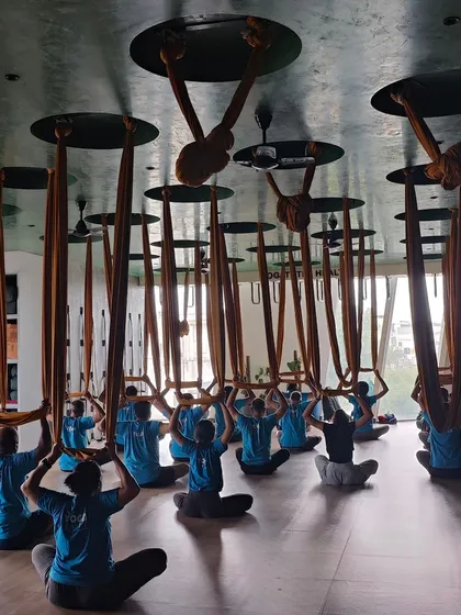 A beautiful, symmetrical shot of my aerial yoga class in a seated meditation pose. This image captures the sense of community, discipline, and shared focus in our studio.