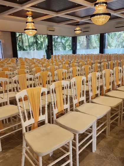 We ensure guest comfort matches the decor's elegance. Here is the seating arrangement for the Green Vidhi ceremony, with chairs adorned with golden sashes.