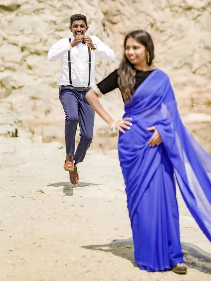A fun and dynamic shot with the groom jumping in the background. This could be from a pre-wedding or even a post-wedding shoot.