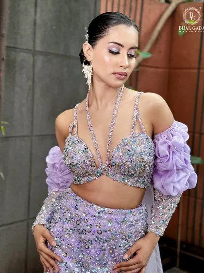 A beautiful shot of the bride in her lilac gown, with soft, diffused lighting enhancing her glowing skin. The makeup is subtle yet impactful, with a focus on a flawless complexion.