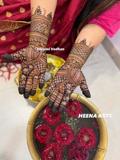 Another view of this intricate design, highlighting the rich henna paste and the detailed patterns on the hands.