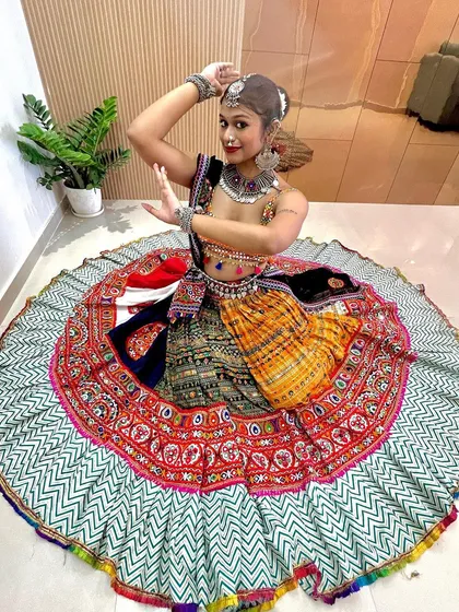 A beautiful seated pose showing the incredible flare of this multi-colored lehenga. The skirt creates a perfect circle, ideal for those dramatic Garba poses.