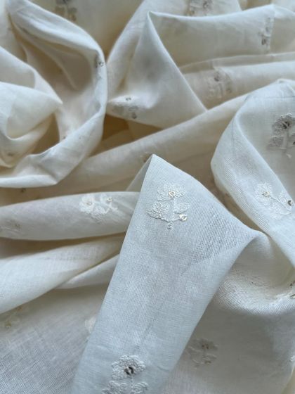 A beautifully draped piece of our white embroidered cotton. The delicate floral butis and sequin accents add a touch of elegance to this natural fabric.