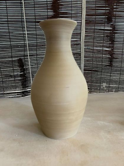 A collection of large, unglazed vases in various shapes and sizes. Each one is thrown on the wheel and showcases a different form, from classic curves to textured surfaces.
