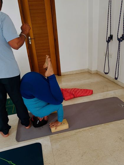 A student works on her headstand with the support of blocks. This modification helps to protect the neck and build confidence while learning the fundamentals of this powerful inversion.