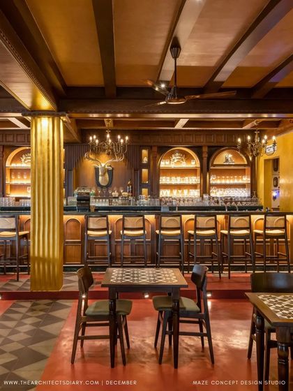 The classic, wood-paneled bar at Adda 1522. With its arched shelving, warm backlighting, and vintage-style chandeliers, this bar is the centerpiece of the indoor section, exuding old-world charm.
