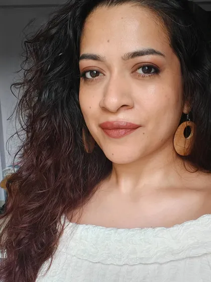 This is my go-to earthy and warm makeup look. I've used bronze tones on my eyes and a terracotta shade on my lips, which I feel complements my skin tone and curly hair beautifully.