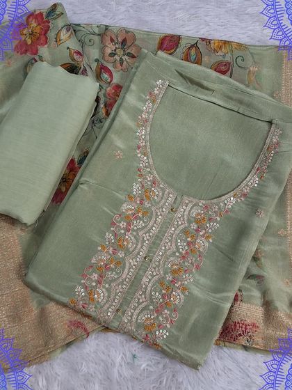A pastel green unstitched suit set with a digitally printed floral dupatta. The top features delicate embroidery, creating a soft and sophisticated look.