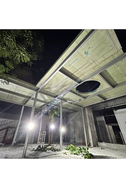 A night shot of the Business Hub under construction. The image shows the ceiling structure being installed, with openings for skylights and services integrated directly into the sustainable panel system.