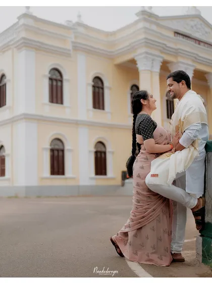 A playful, romantic pose in front of a colonial-era building in Mysore, showcasing the city's diverse architectural beauty for a pre-wedding session.