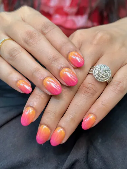 I am obsessed with this vibrant ombre look. We blended a sunset orange and a bright pink gel polish and then finished it with a chrome powder to give it that incredible, eye-catching sheen.