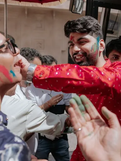 The groom joyfully participates in the Holi welcome, sharing a moment of fun with his guests. We believe in creating interactive experiences for everyone.